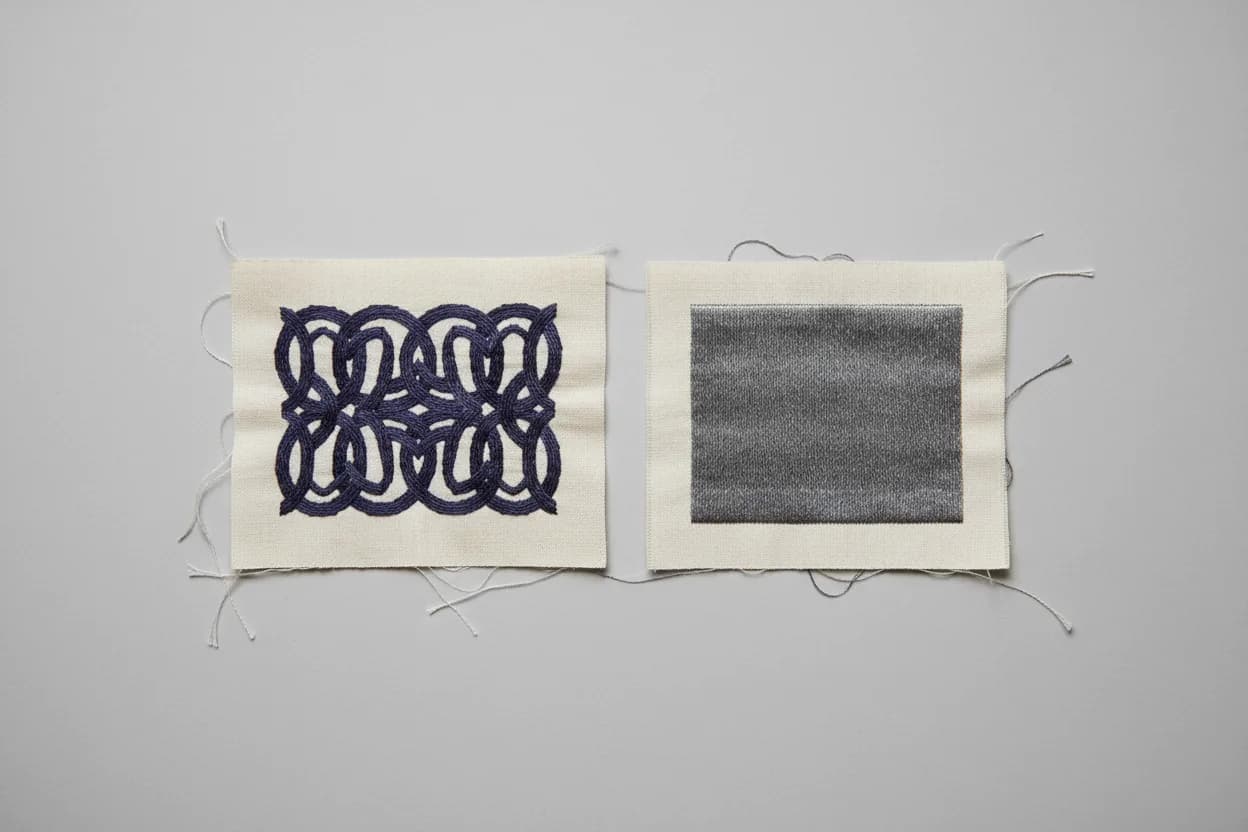 Broderie au point de chaînette comparée : motif entrelacé marine et aplat gris sur toile écrue